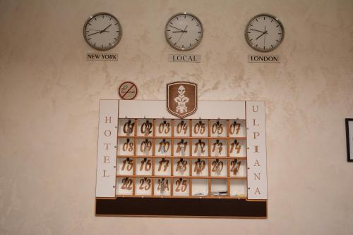 a display case with clocks on a wall at Hotel Ulpiana, Ethno House in Gracanica