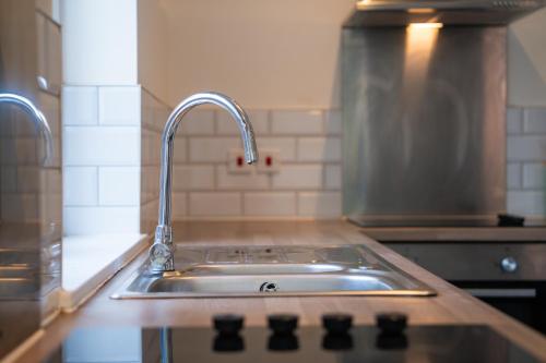 a kitchen sink with a faucet on top of it at Group Stay Paradise 7 Bedrooms, All with En-Suites in Canterbury