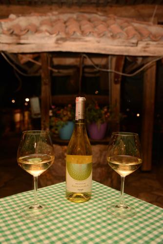 two glasses of white wine sitting on a table at Hotel Ulpiana, Ethno House in Gracanica