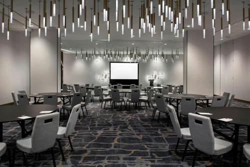 a conference room with tables and chairs and a screen at Marriott Springfield Downtown in Springfield