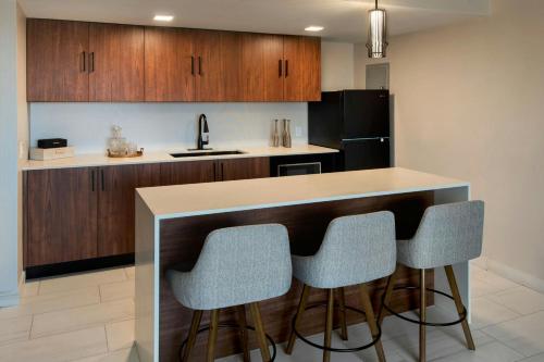 a kitchen with a bar with three stools at Marriott Springfield Downtown in Springfield