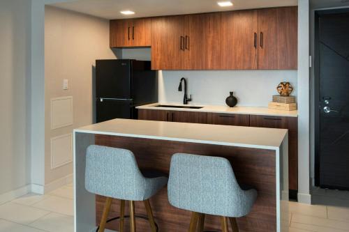 a kitchen with a counter and two bar stools at Marriott Springfield Downtown in Springfield