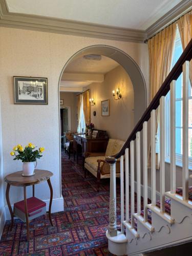a living room with a staircase and a living room with a couch at Lower Bryanston Farm in Blandford Forum