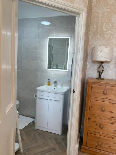 a bathroom with a white sink and a mirror at Lower Bryanston Farm in Blandford Forum