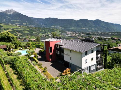 a house in a vineyard with mountains in the background at Alagundis Apartment Residence in Lagundo