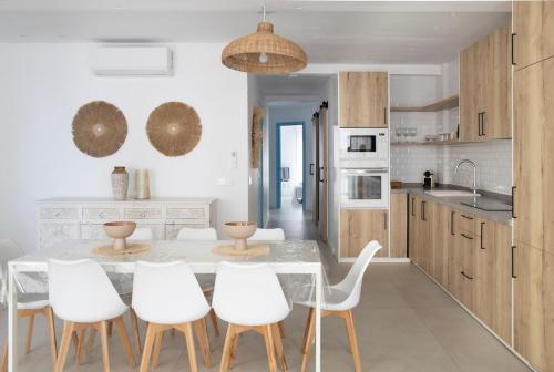 cocina con mesa de comedor y sillas blancas en Gran apartamento Sorolla, en Playa de Miramar