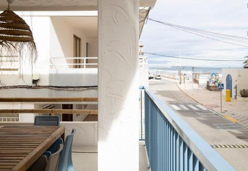 Un balcón con una mesa y vista a una calle. en Gran apartamento Sorolla, en Playa de Miramar