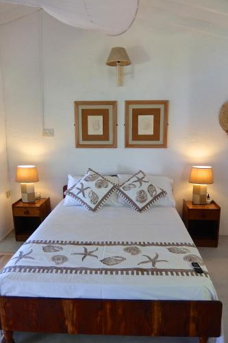 a bedroom with a large bed with two lamps at Vi Miles Lodge in Mahe