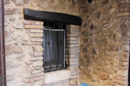 a window in a stone wall with a metal grate at Santa Rufè in Santa Rufina