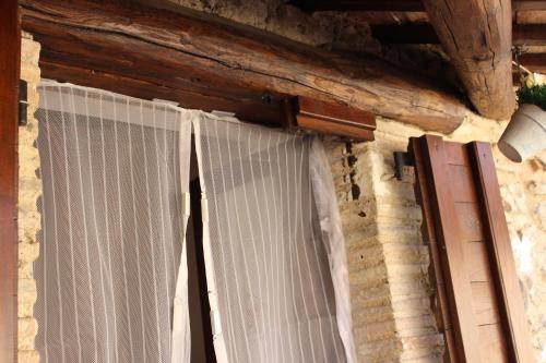 a window with curtains on the side of a building at Santa Rufè in Santa Rufina