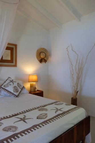a bedroom with a bed and a lamp on a table at Vi Miles Lodge in Mahe