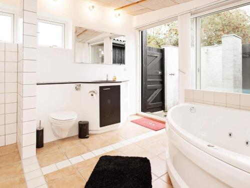 a bathroom with a tub and a toilet and a sink at 6 person holiday home in Dronningmølle-By Traum in Dronningmølle