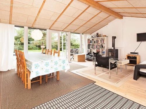 a living room with a dining room table and chairs at 6 person holiday home in Dronningmølle-By Traum in Dronningmølle
