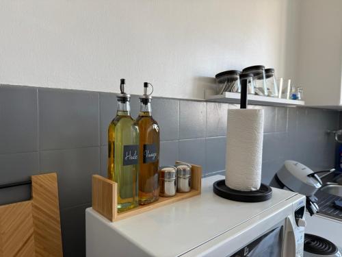 two bottles of wine sitting on top of a kitchen counter at Studio cosy en hypercentre de Louviers in Louviers