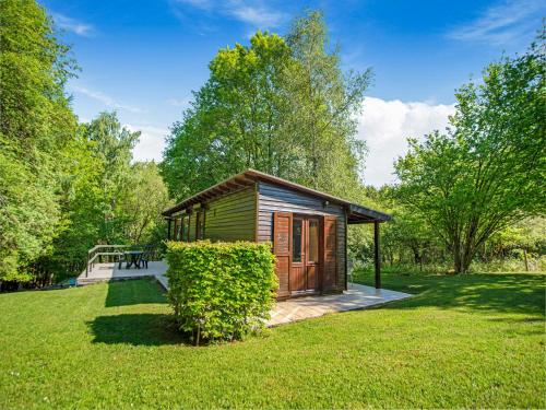 a small wooden cabin in a field of grass at Seneric Chalet, Trois-Ponts in Trois-Ponts
