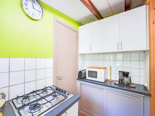 a kitchen with a stove and a clock on the wall at Seneric Chalet, Trois-Ponts in Trois-Ponts