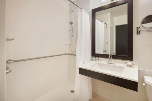 a bathroom with a sink and a shower with a mirror at Courtyard New York Manhattan/Times Square in New York