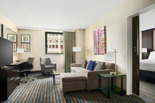 a hotel room with a couch and a bed at Courtyard New York Manhattan/Times Square in New York