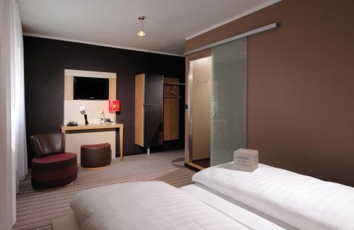 a hotel room with a bed and a desk at Leonardo Boutique Hotel Munich in Munich