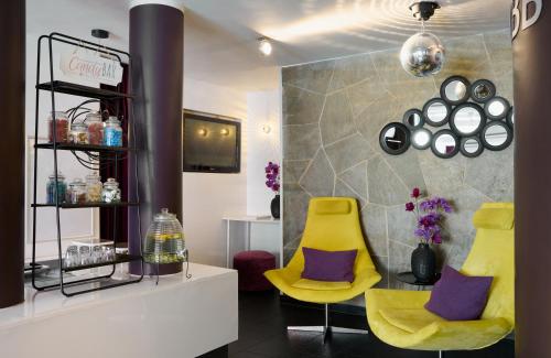 a salon with two yellow chairs and purple pillows at Leonardo Boutique Hotel Munich in Munich