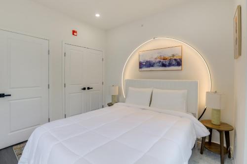 a white bedroom with a white bed and a mirror at Penthouse Condo with Rooftop Deck in Philadelphia! in Philadelphia