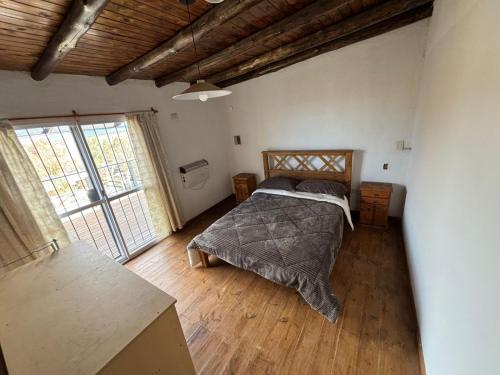 a bedroom with a bed and a large window at CABAÑAS EL CERRO in Ciudad Lujan de Cuyo