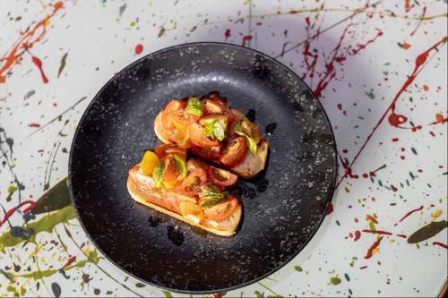 a black plate with a piece of food on it at NYX Hotel Dublin Portobello in Dublin
