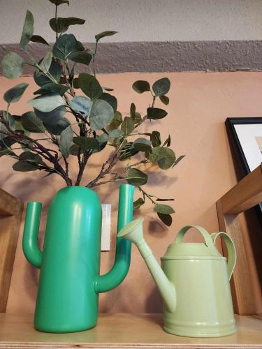 two green vases sitting on a table with a plant at In68 House in Ch'ih-k'an-lou