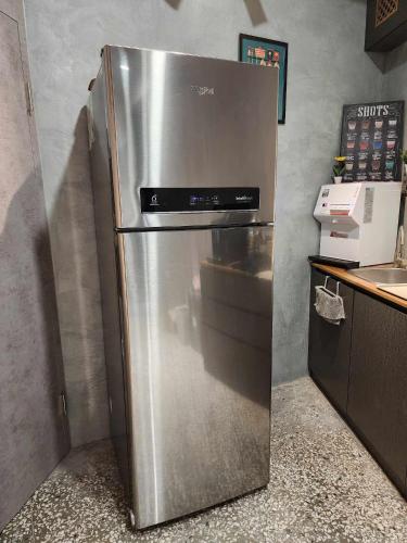a stainless steel refrigerator in a kitchen next to a counter at In68 House in Ch'ih-k'an-lou