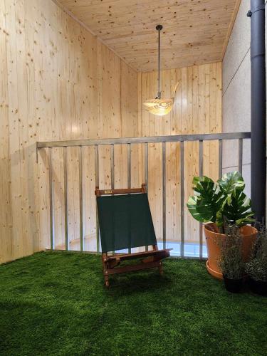 a green chair sitting on the grass in a room at In68 House in Ch'ih-k'an-lou