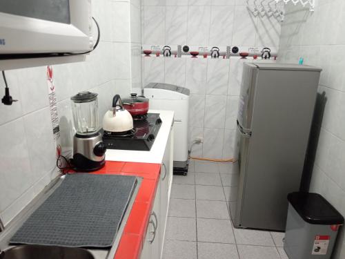 a small kitchen with a stove and a refrigerator at Cusco House como en casa in Cusco
