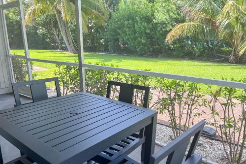 a table and chairs on a porch with a view of a yard at Marco Island Lakeside Inn in Marco Island