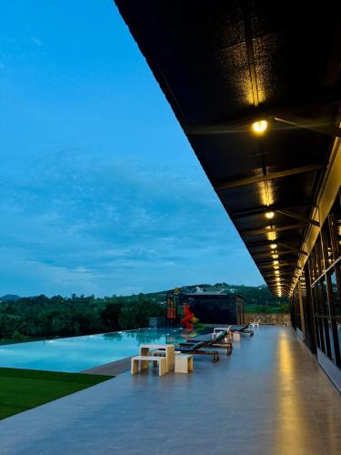 a building with a large swimming pool with lights on it at GrandWara Khao Yai แกรนด์วารา เขาใหญ่ in Ban Nong Song Hong