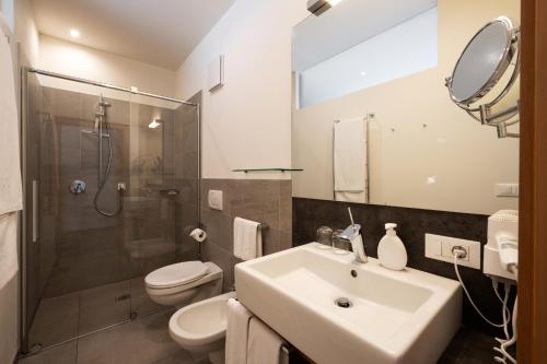 a bathroom with a sink and a toilet and a shower at Alagundis Apartment Residence in Lagundo