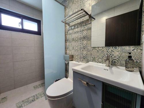 a bathroom with a sink and a toilet and a mirror at In68 House in Ch'ih-k'an-lou