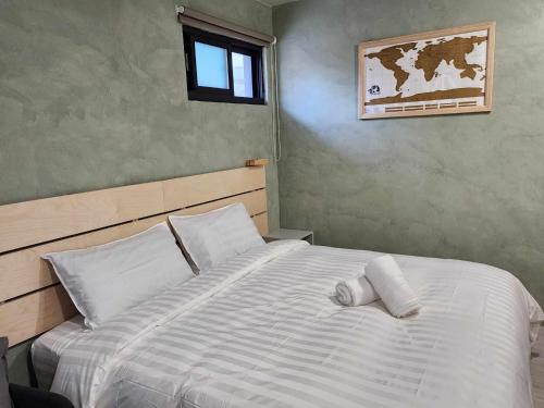 a bedroom with a large white bed with a window at In68 House in Ch'ih-k'an-lou