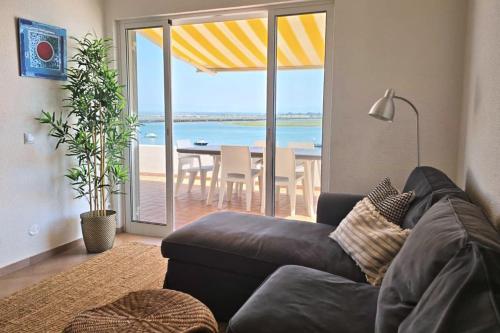 a living room with a couch and a view of the ocean at Beach House on Faro Island with a Dreamy Terrace and 7 Beds for the Perfect Escape in Faro
