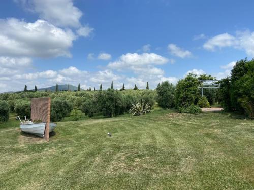 a garden with a boat in the middle of a field at Wonderfull counrty villa, views on sea & Capalbio in Pescia Fiorentina
