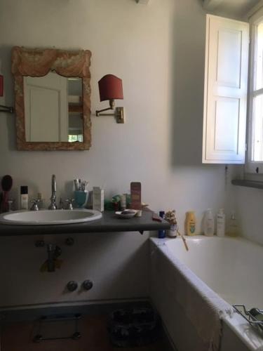 a bathroom with a sink and a tub and a mirror at Wonderfull counrty villa, views on sea & Capalbio in Pescia Fiorentina