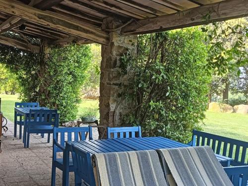 a group of blue tables and chairs under a woodenilion at Wonderfull counrty villa, views on sea & Capalbio in Pescia Fiorentina