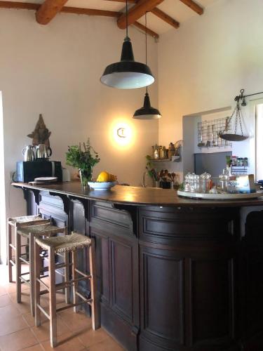 a kitchen with a large wooden island with bar stools at Wonderfull counrty villa, views on sea & Capalbio in Pescia Fiorentina