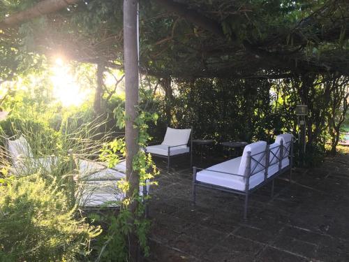 two white chairs sitting under a pergola at Wonderfull counrty villa, views on sea & Capalbio in Pescia Fiorentina