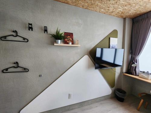 a living room with a tv on a wall at In68 House in Ch'ih-k'an-lou
