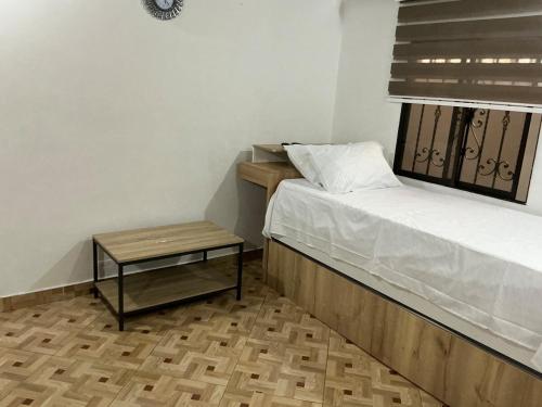 una piccola camera da letto con un letto e un tavolo di Aparta suite Torre de Prado 402 a Medellín