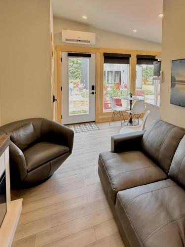 a living room with a leather couch and a table at Royalty Maples Motel & Cottages in Charlottetown