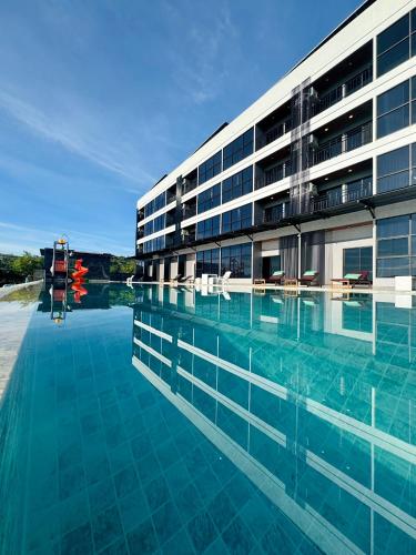 a large building with a swimming pool in front of it at GrandWara Khao Yai แกรนด์วารา เขาใหญ่ in Ban Nong Song Hong