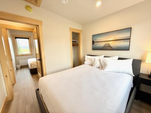 a bedroom with a large bed with white sheets at Royalty Maples Motel & Cottages in Charlottetown