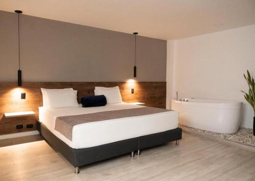 a bedroom with a large bed and a bath tub at Fence by Bernalo Hotels in Medellín