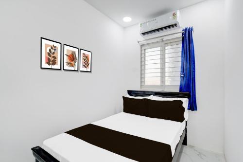 a bedroom with two beds and a window at Hotel O R J Residency in Pedda Ambarpet