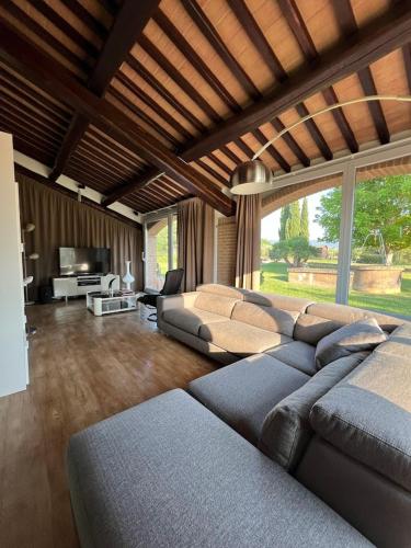 a living room with a large couch and a television at Villa Tattoo in Donoratico
